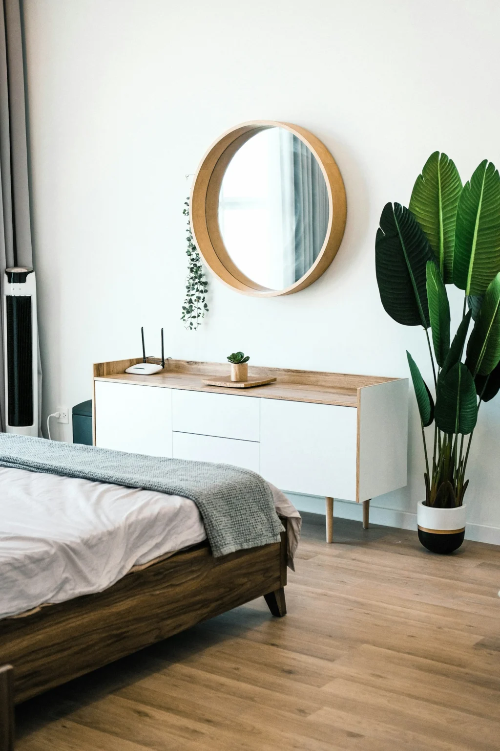 Bedroom with wooden sideboard and round mirror