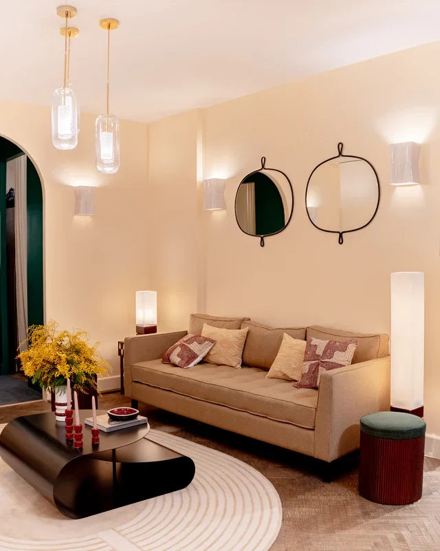 Warm lit lounge with sofa and round mirrors